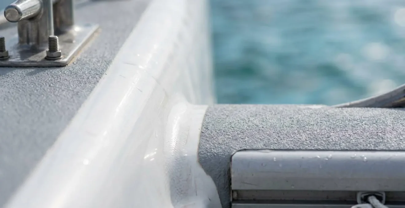 Vue aérienne rapprochée d'un catamaran au mouillage illustrant la stabilité de ses deux coques parallèles dans une eau calme et turquoise