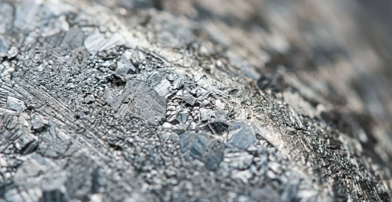 Vue macro d'une surface métallique en acier inoxydable montrant la texture et les contraintes matérielles