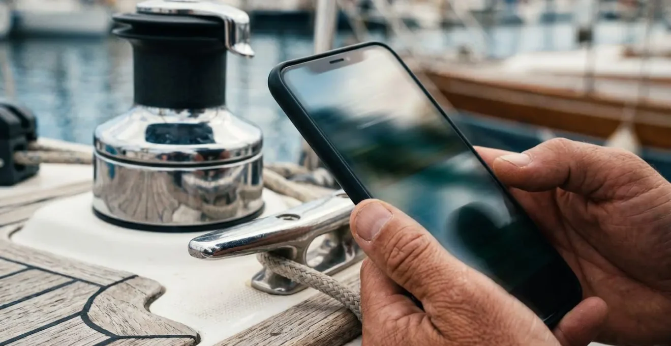 Gros plan sur un smartphone capturant une photo certifiée horodatée d'un équipement de bateau