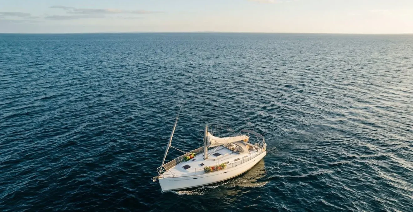 Vue aérienne d'un voilier hauturier en navigation avec filets de stockage suspendus à l'extérieur et espace de vie organisé