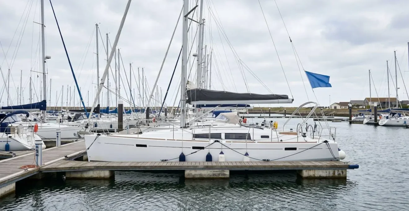 Voilier de croisière moderne au franc-bord élevé amarré dans un port par temps venté